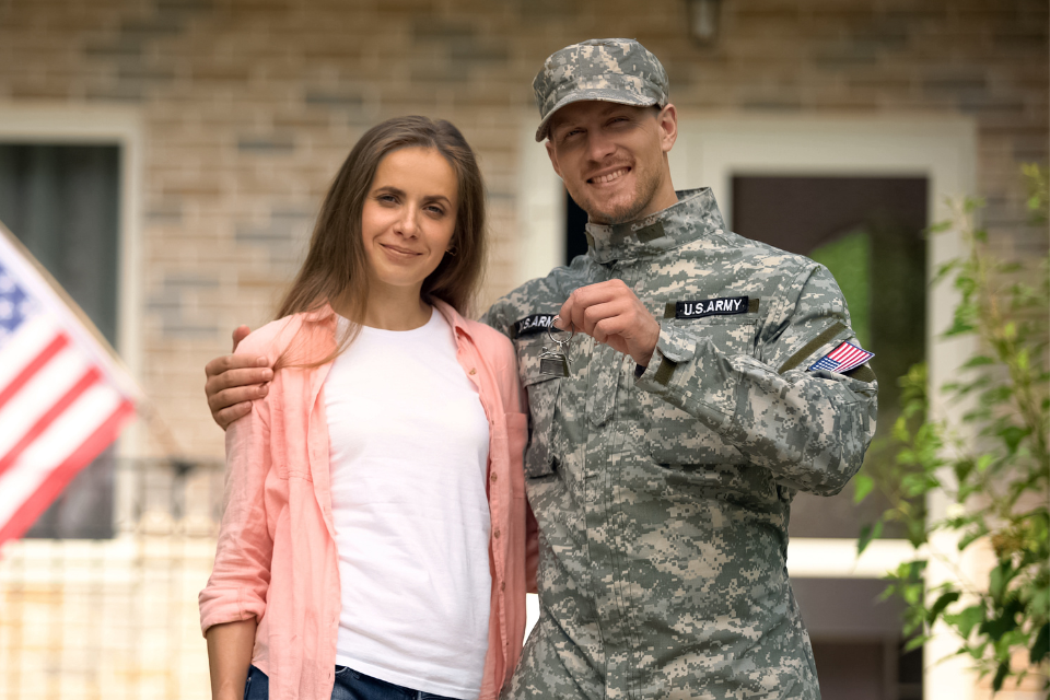 A military couple with keys to new home from VA home loan.